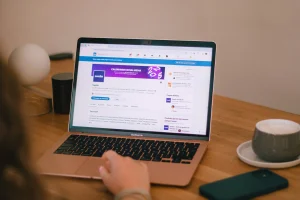 Person browsing LinkedIn on a MacBook Air, exploring freelancing platforms and job opportunities online in 2025.