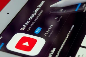Close-up of YouTube app page on tablet screen, showing ratings and download option for video content creation and streaming.
