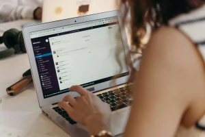 Woman using Slack on a laptop for remote team communication, collaboration, or online work in a freelance or startup setting.
