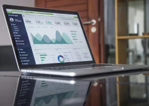 Open laptop displaying analytics dashboard with graphs, charts and user data for business performance tracking